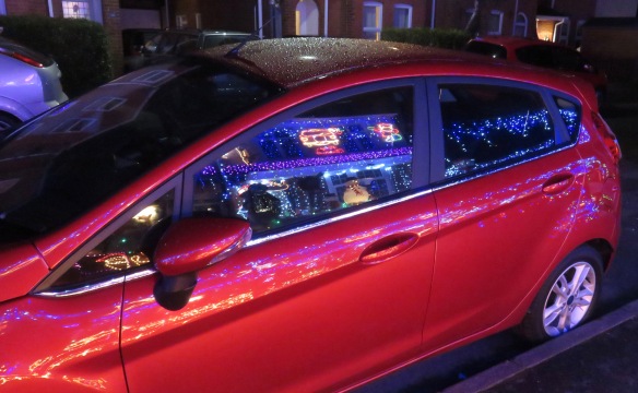 Christmas lights reflected in car