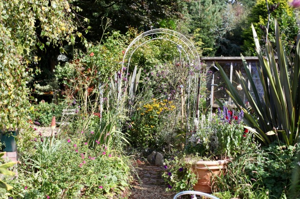 Garden view through arch towards Oval Bed