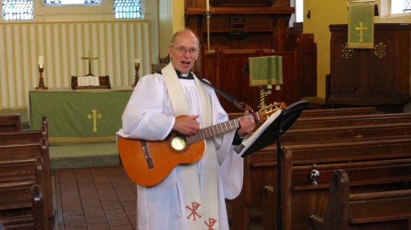Rev David Farey playing guitar
